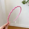 Pink wavy headband detail shot, glossy finish hair hoop with teeth for sweet daily styling. - Pink