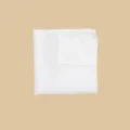 Vue détaillée d'une pochette de costume blanche, montrant la texture et le pliage. - Blanc