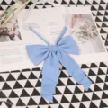 Close up view of light blue solid color big bow tie for JK uniform, featuring fine pleated fabric. - 003