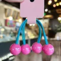 Detailed close-up of colorful cute candy-style spherical hair ties with vibrant beads. - Rose Red