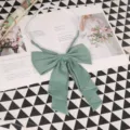 Close-up detail of the elegant green JK uniform bow tie with layered pleats and elastic strap. - 008
