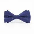 Close-up of a dark blue bow tie with subtle silver pattern, textured fabric detail. - Dark Blue