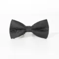 Close-up detail of a black classic men's bow tie featuring intricate woven paisley patterns. - Color 014