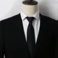 Primo piano di una cravatta nera elegante abbinata a camicia bianca e abito formale. - A005