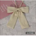 Detail shot of beige JK uniform bow tie, featuring smooth texture and elegant flat corner design. - Beige