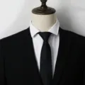 Gros plan détaillé d'une cravate noire classique à rayures portée avec un costume formel. - A006