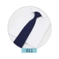 Close-up detail of a dark blue solid men suit tie displayed on a crisp white shirt. - Color 011