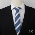 Detail view of men's classic blue and beige striped business tie paired with suit. - Style 030
