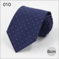 Detail view of a classic blue men's business necktie featuring elegant white polka dot pattern. - No. 010