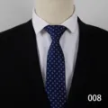Detailed view of a classic blue dot men business tie worn with a white shirt and black suit. - Type B 008