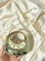 Nahaufnahme der goldenen metallischen Crescent-Umhängetasche mit Glitzerbuchstaben und Kette. - A118 Stil / Blau