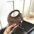 Details der modischen rosa Glitzer-Handtasche mit goldenem Ringgriff und Kette. - Rosa