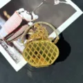 Detailaufnahme einer goldenen geometrischen Abendtasche mit Strass-Rundgriff und Kette. - Geometrischer Rautenmusterstil (A111) / Gold