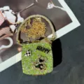 Nahaufnahme der Mini Strass Abendtasche mit funkelnden Kristallen, Kette und Bär. - Grün (A091)