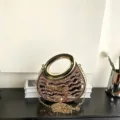 Exquisite Detailansicht der glitzernden Strass-Abendtasche mit eleganter Metallkette und Griff. - Rosa