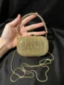 Detailansicht der luxuriösen goldenen Strass-Abendtasche mit glitzerndem Griff und Kette. - Gold