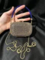 Detailansicht der luxuriösen blauen und goldenen Strass Abendtasche mit Kette und Griff. - Blau