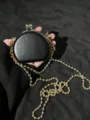 Detailgezicht van de zwarte mini-kiss-lock tas met een stijlvolle gouden kogelketting-schouderriem. - Zwart (Gouden Dubbele Kralenketting)