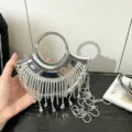 Borsa da sera mini semicircolare metallica argentata con frange di strass scintillanti. - Argento A137