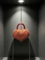 Primo piano di una mini borsa da sera a forma di cuore scintillante di strass rossi. - Rosso