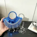 Nahaufnahme der glänzenden blauen Mini-Abendtasche mit funkelnden Strassfransen und Griff. - A137 Blau