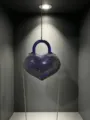 Primo piano della borsa da sera a cuore in cristallo brillante con manico e catena. - Blu