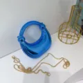 Glänzende blaue hohle Ring Handtasche Detail, edles glänzendes Acryl mit goldener Kette. - Blau