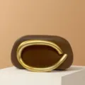 Close-up of mini brown leather shoulder bag featuring a striking gold metal circular handle. - Matte Handle / Dark Brown