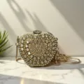 Detailansicht der glitzernden Kristall Apfel Clutch Tasche mit goldener Kette auf Marmor. - A061 Gold