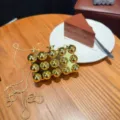 Dettaglio della borsa da sera metallica dorata con borchie sferiche uniche e catena. - C005 Oro