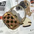 Dettaglio pochette da sera mini in strass, guscio acrilico dorato di lusso con catena di cristalli. - Arancione