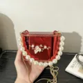 Dettaglio della borsa rigida in acrilico rosso con manico di perle e decoro floreale. - Serie A141 / Rosso