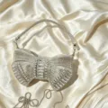 Sparkling rhinestone bow evening bag detail showcasing brilliant crystal embellishments. - Silver