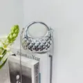 Silver metallic quilted mini bag with circular handle and chain strap for stylish women. - Silver