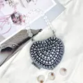 Detailaufnahme einer glitzernden Strass-Herz-Tasche mit klarem Perlenhenkel und Verschluss. - A024 Schwarz