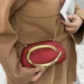 Vista dettagliata della mini borsa da sera rétro con manico metallico dorato a forma di C. - Stile Opaco / Rosso Opaco