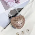 Nahaufnahme der glitzernden herzförmigen Mini-Tasche mit klarem Perlenhenkel und Strasssteinen. - A023 Champagner