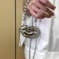 Detailansicht einer silbernen Lippen-Miniclutch aus Metall mit Perlenhenkel und Kettenriemen. - Lippen (Große Perlenkette) / Silber