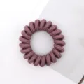 Detail shot of a braided phone wire hair tie in mauve, soft elastic hair accessory for daily styling. - Dark Red
