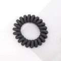 Black telephone wire hair tie detail, showing elastic texture and spiral shape close up. - Black and Gray