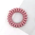 Detailed view of a pink fabric telephone wire hair tie, perfect for daily hairstyles. - Pink