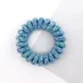 Close-up detail of blue and green woven spiral hair tie, showing delicate braided texture. - Multicolor Teal Blue