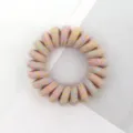Detailed shot of a colorful woven telephone cord hair tie, stylish and elastic hair accessory. - Multicolor Light Warm Tone