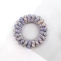 Detail shot of retro woven telephone wire hair tie with blue and beige pattern, high elasticity. - Multicolor Light Blue