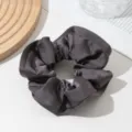 Close up detail shot of a dark grey satin hair scrunchie, smooth fabric, elegant accessory. - Dark Gray (Ruffle Trim Scrunchie)