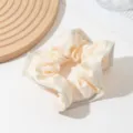 Elegant cream satin hair scrunchie detail, soft texture accessory for women ponytail styling. - Off-White (Ruffle Trim Scrunchie)