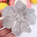 Close up of sparkling rhinestone flower patch detail, shiny crystal garment accessory. - White