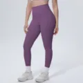 Detail shot of high-waisted purple yoga pants worn by model, showing fitted silhouette and fabric. - S / Bottoms / Purple Thistle