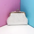 Primer plano del mini monedero plateado con cierre de boquilla y elegante tejido texturizado. - Blanco