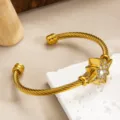 Gold twisted cable cuff bracelet featuring an elegant sparkling star zircon crystal design. - Gold